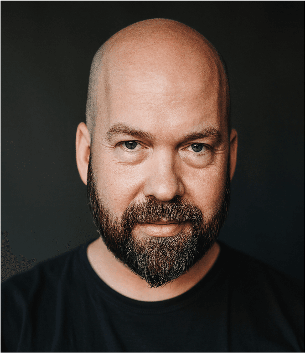 Josh Jackson, bald with a full beard, in a black t-shirt